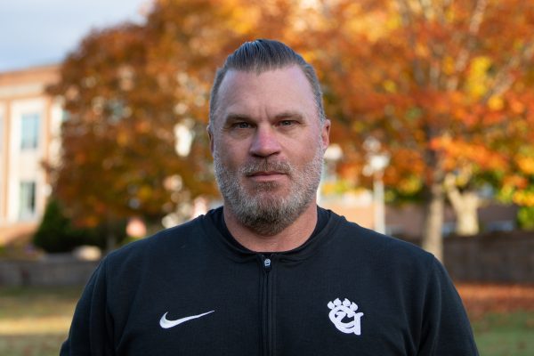 A photo of Brian Ferguson featuring an Autumn backdrop, highlighted by orange Fall foliage.