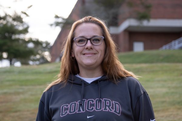 An image of Jessica Bailey standing in front of a grassy knoll on the Concord Campus.