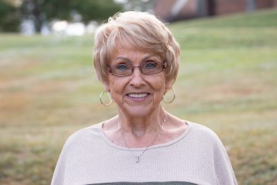 An image of Loran Morgan standing in front of a grassy knoll on the Concord Campus.