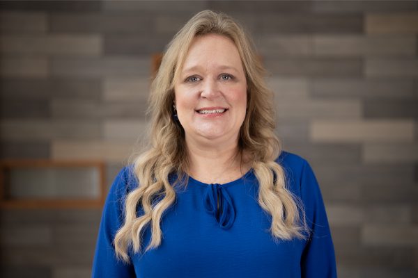Mindy Hawkins standing in front of a gray wall in University Point