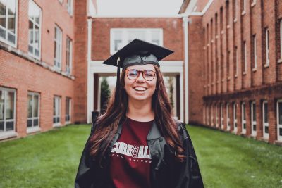 Dara Ladner wearing her cap, gown, and Concord tshirt