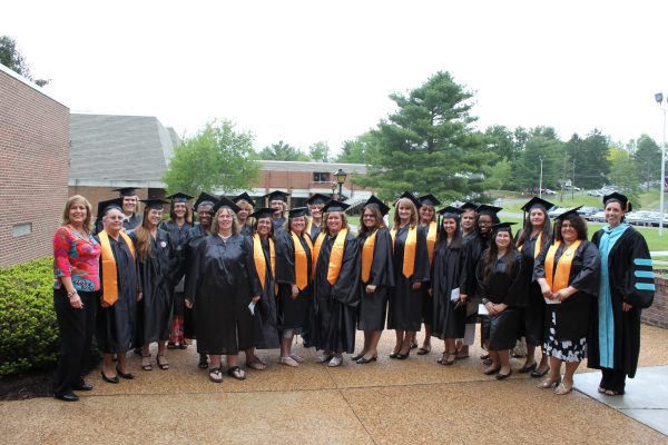 CU Early Childhood Regents Bachelor of Arts graduates standing together in their caps and gowns