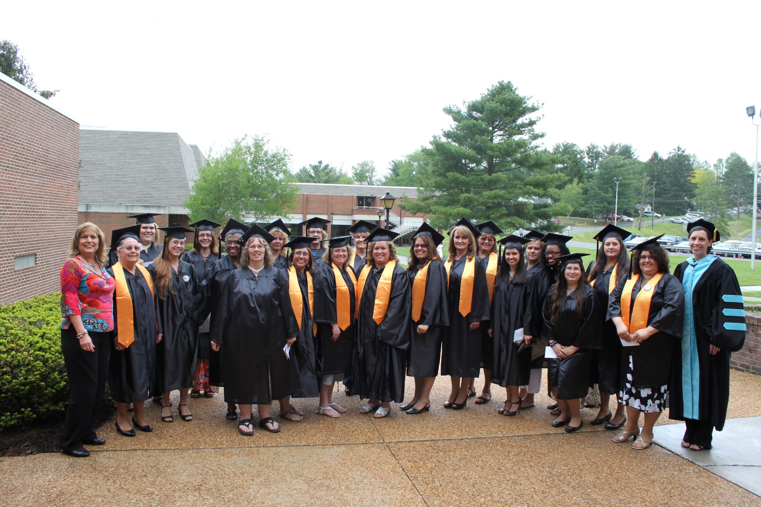 CU Early Childhood Regents Bachelor of Arts graduates standing together in their caps and gowns