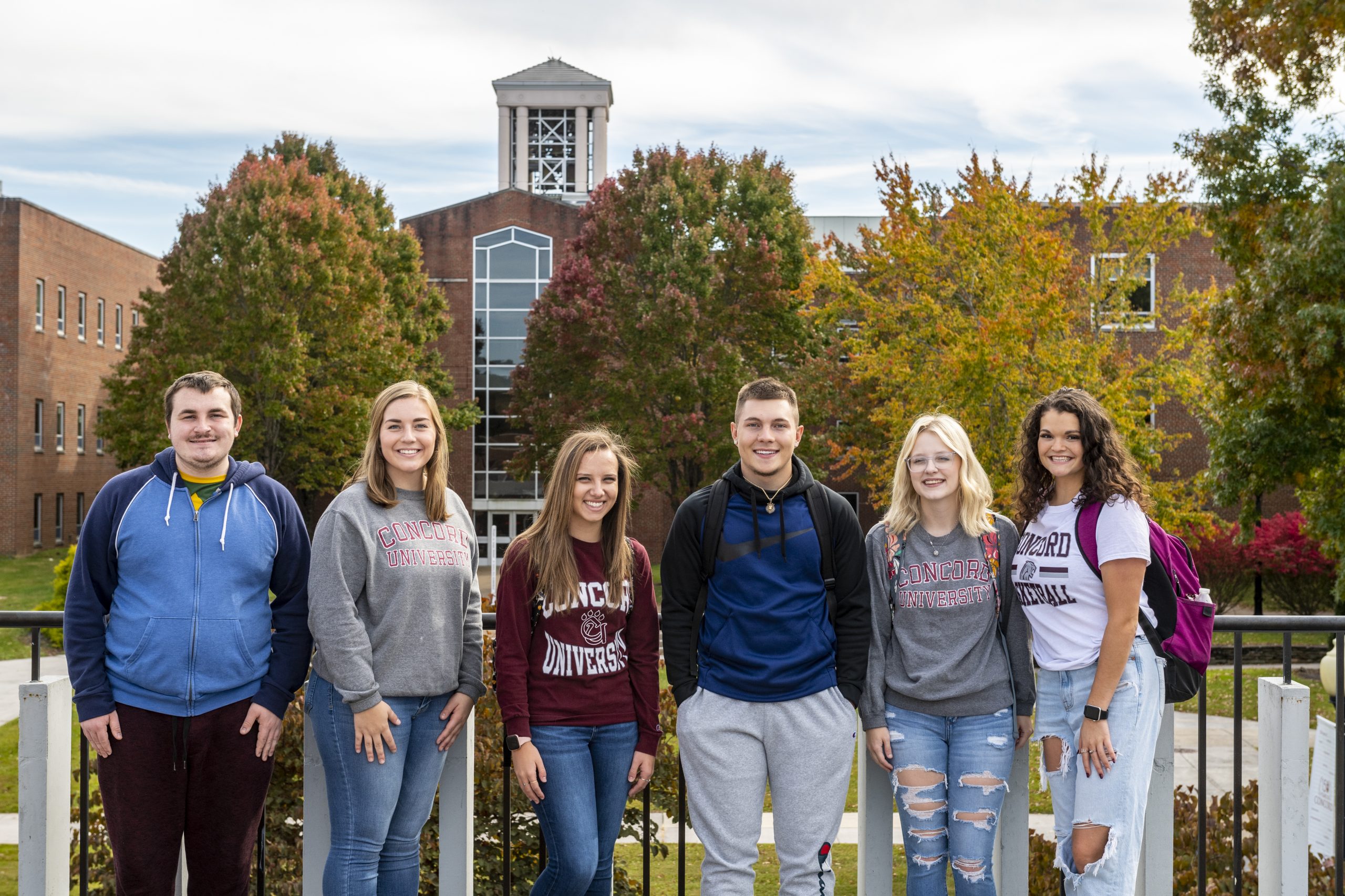 A group of students standing in front of the bell tower at Concord University