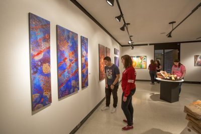 Students looking at artwork in the Concord University art gallery