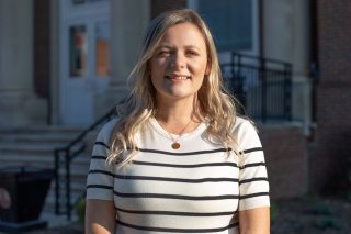 A photo of Ashley Cook standing in front of the J. Franklin Marsh Library at Concord University