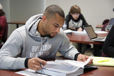 A business student reading his textbook in class