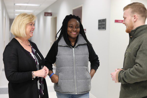 Dr. Robinett talking to two business students