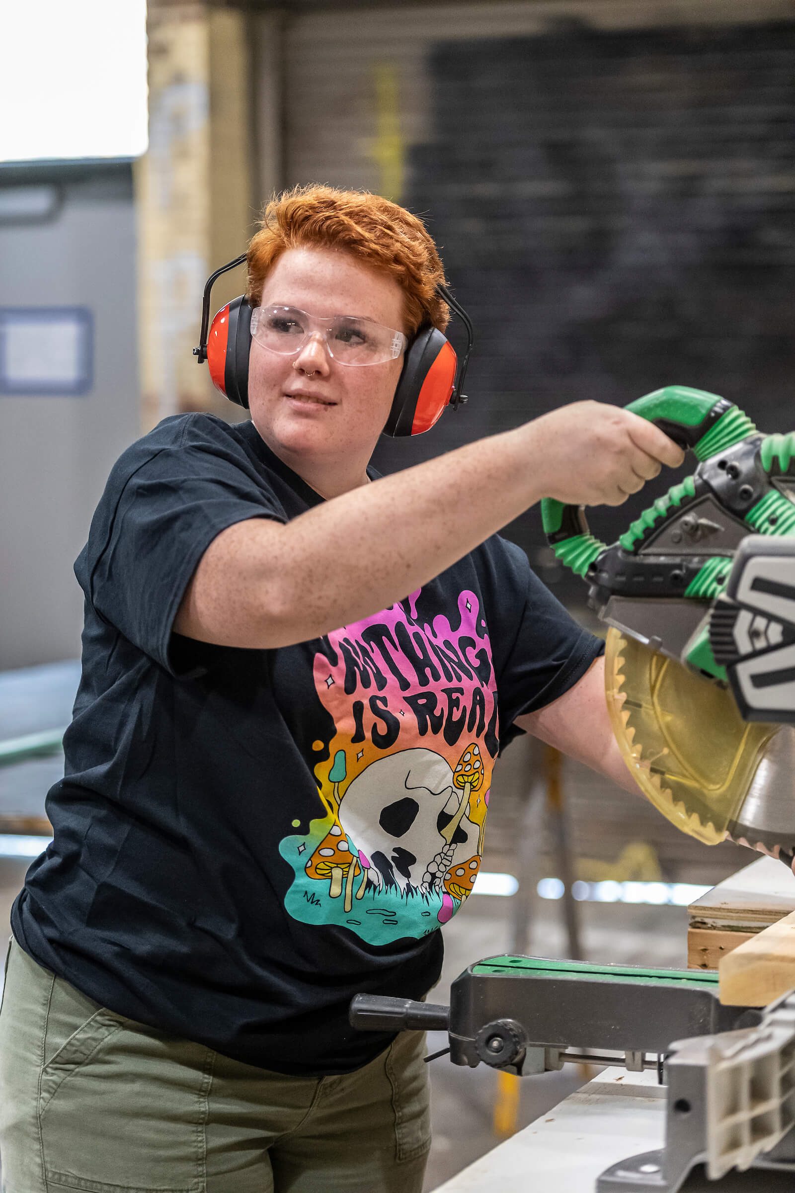 A Concord student cutting wood to help build a set