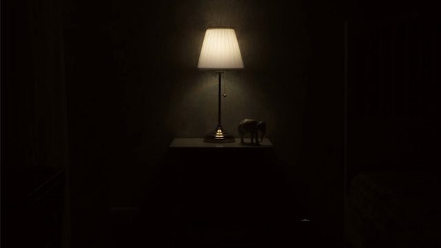 A photo of a lit lamp in a very dark room