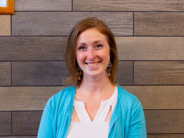 A photo of Jillian Cockerham standing in front of a slate tile wall in University Point