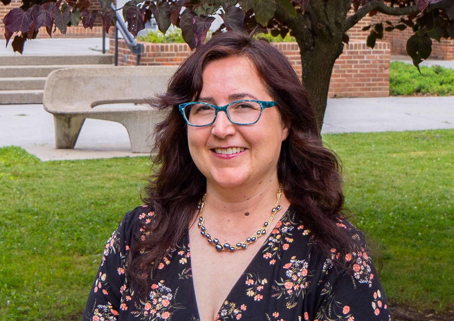 A photo Beth Little standing in front of the Alexander Fine Arts Building.