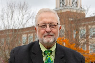 A photo of Jim Owston standing in front of the Concord bell tower