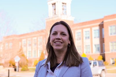 A photo of Andrea Campbell with Concord University's iconic bell tower in the background.