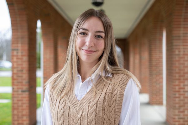 A photo of Amanda Banfield standing in front of the entrance to University Point