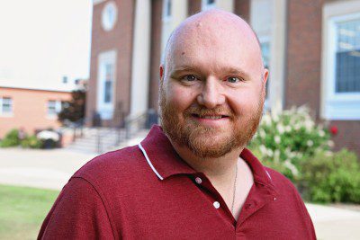 A photo of Jonathan Bolt standing in front of the J. Franklin Marsh Library