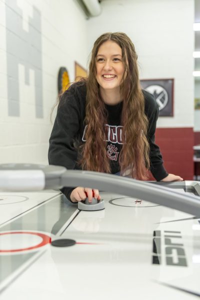 A student playing air hockey in the Concord University game room