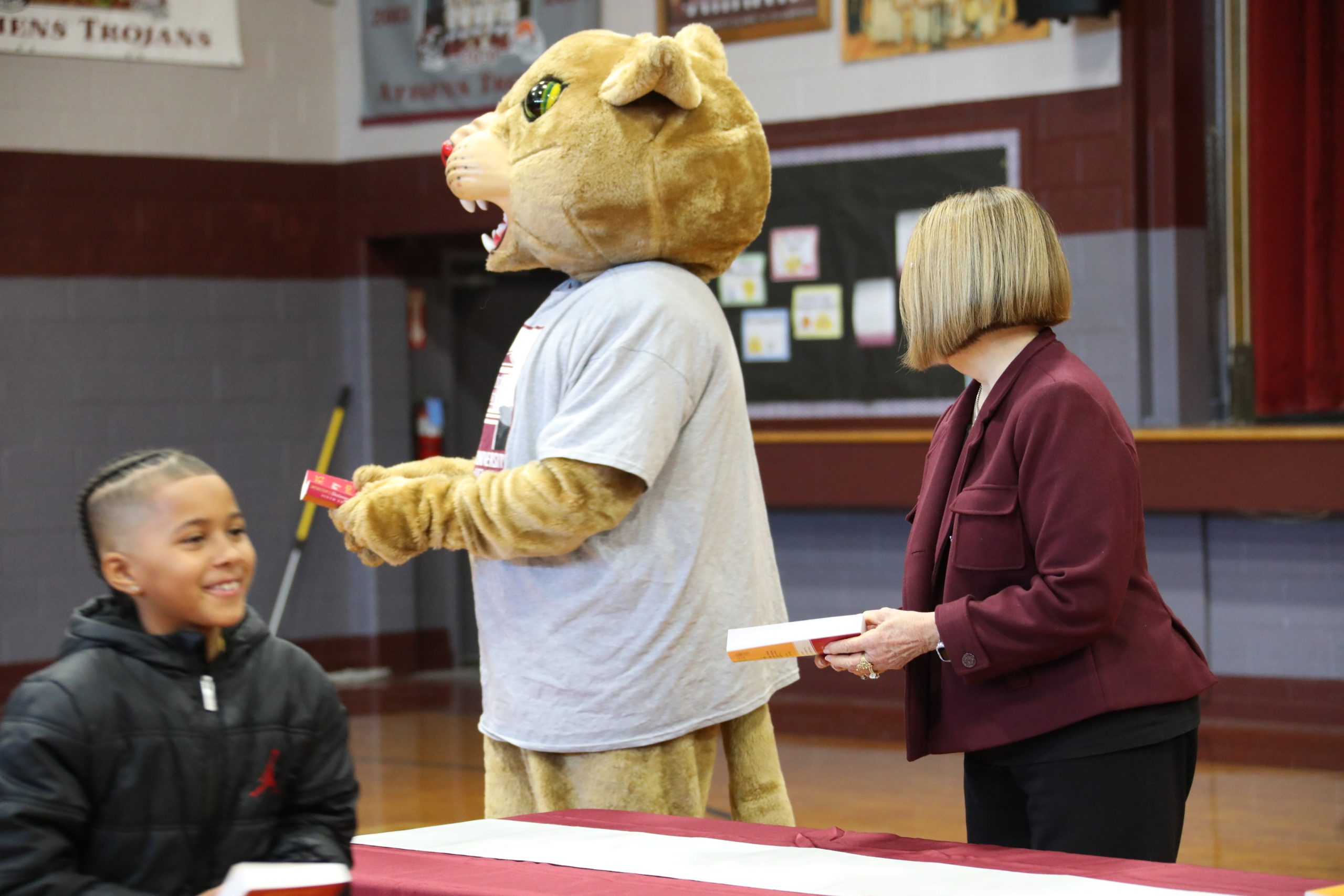 Concord University mascot Roar and President Boggess handing out dictionaries to Mercer County third grade students