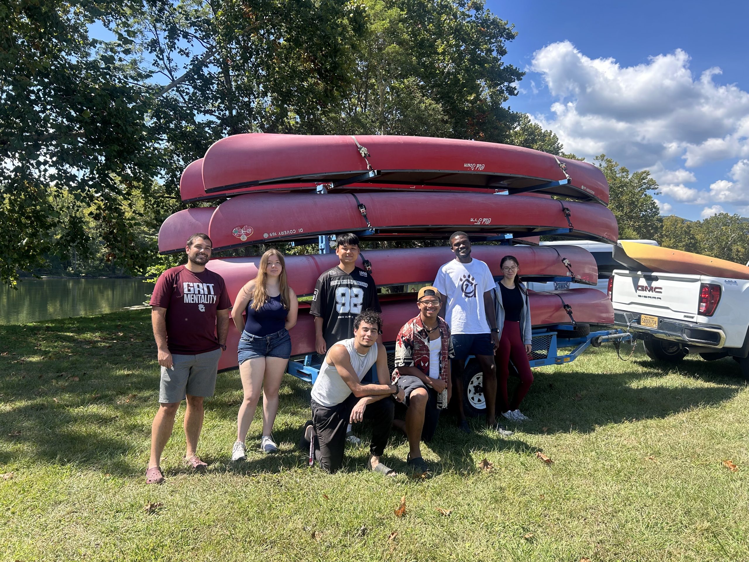 Students posing in front of canoes