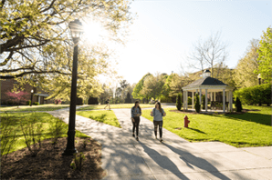 Two students walking together by the Fine Arts center