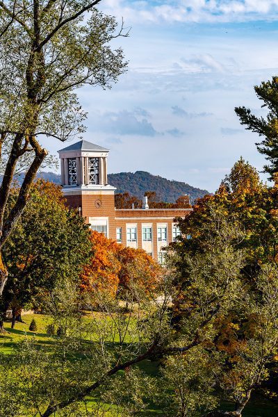 The Concord University bell tower as seen through some tall autumn trees