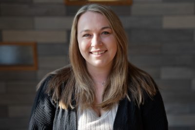 A photo of Kristen Brown in front of a gray slate background