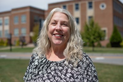 A photo of Lori Pace in front of Marsh Hall