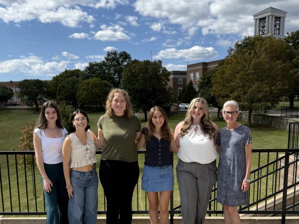 Members of Pi Sigma Alpha standing on a balcony overlooking the CU Bell Tower
