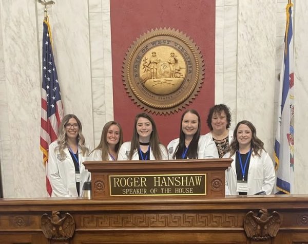 Concord BSN students pose behind the podium of West Virginia's Speaker of the House Roger Hanshaw