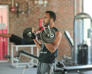 A student lifting weights in the fitness center