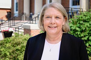 A photo of Dr. Kathy Liptak in front of J. Franklin Marsh Library