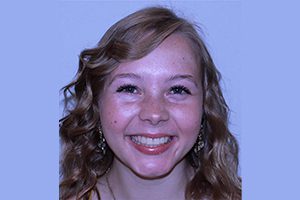 Sarah Angell in front of a purple background